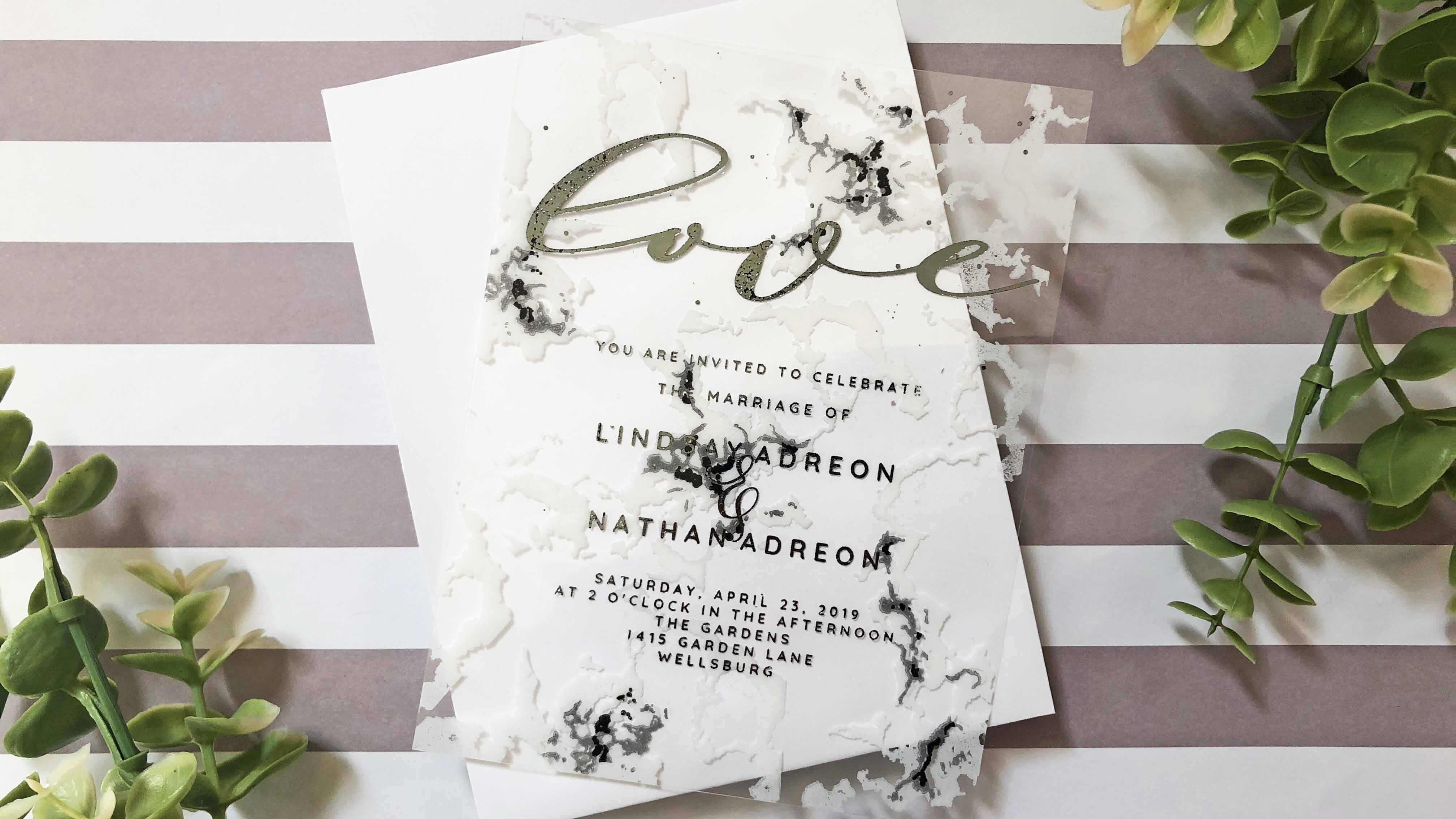 DIY clear wedding invitations with a marble pattern.