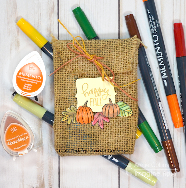 In this crafting lesson, Annie shows you a quick and easy Halloween Trick or Treat candy bag made with burlap material, pumpkin stamps, and Memento dye inks.